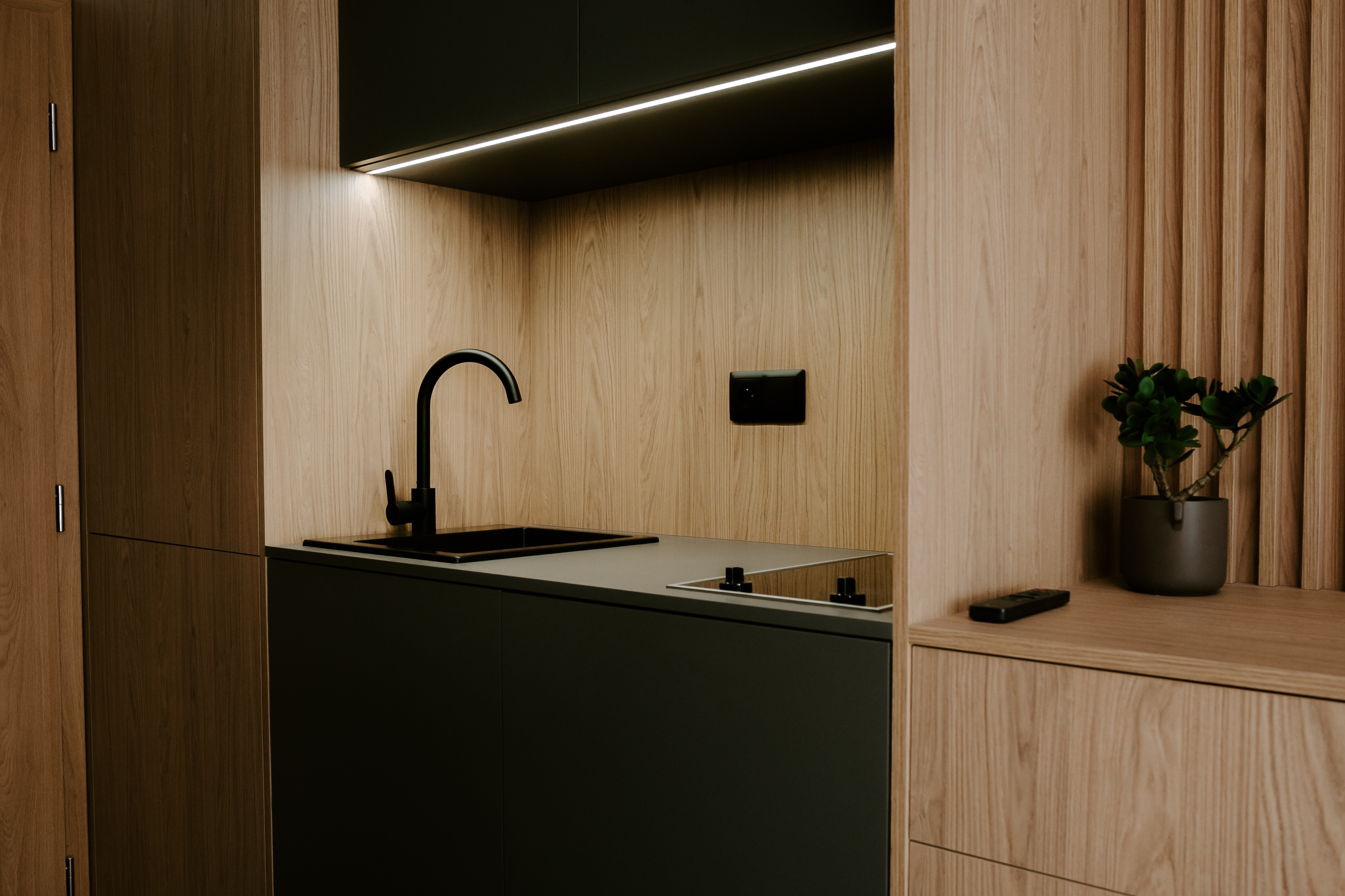 Detail kuchyňského koutu s dřezem a indukční varnou deskou