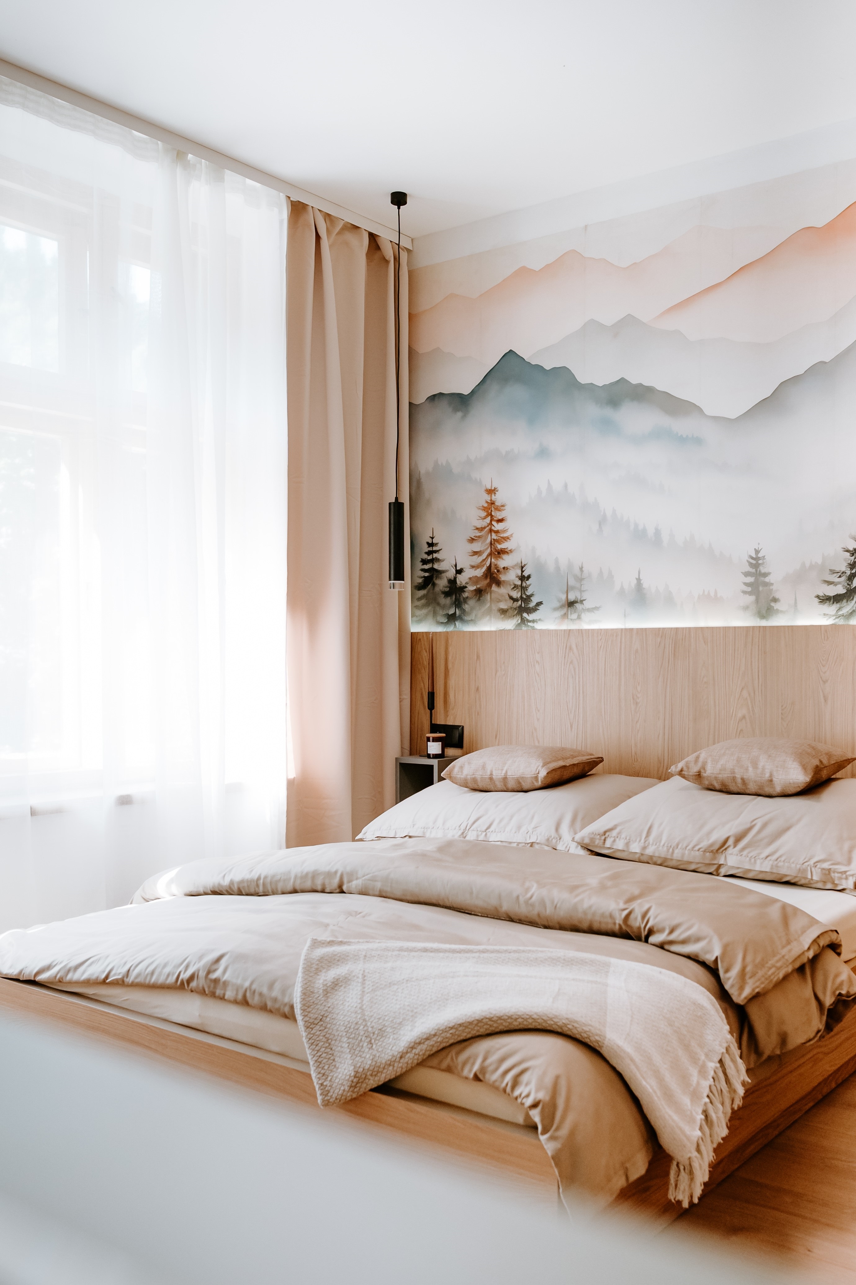 Ložnice apartmánu s dřevěným obkladem a výhledem do hor