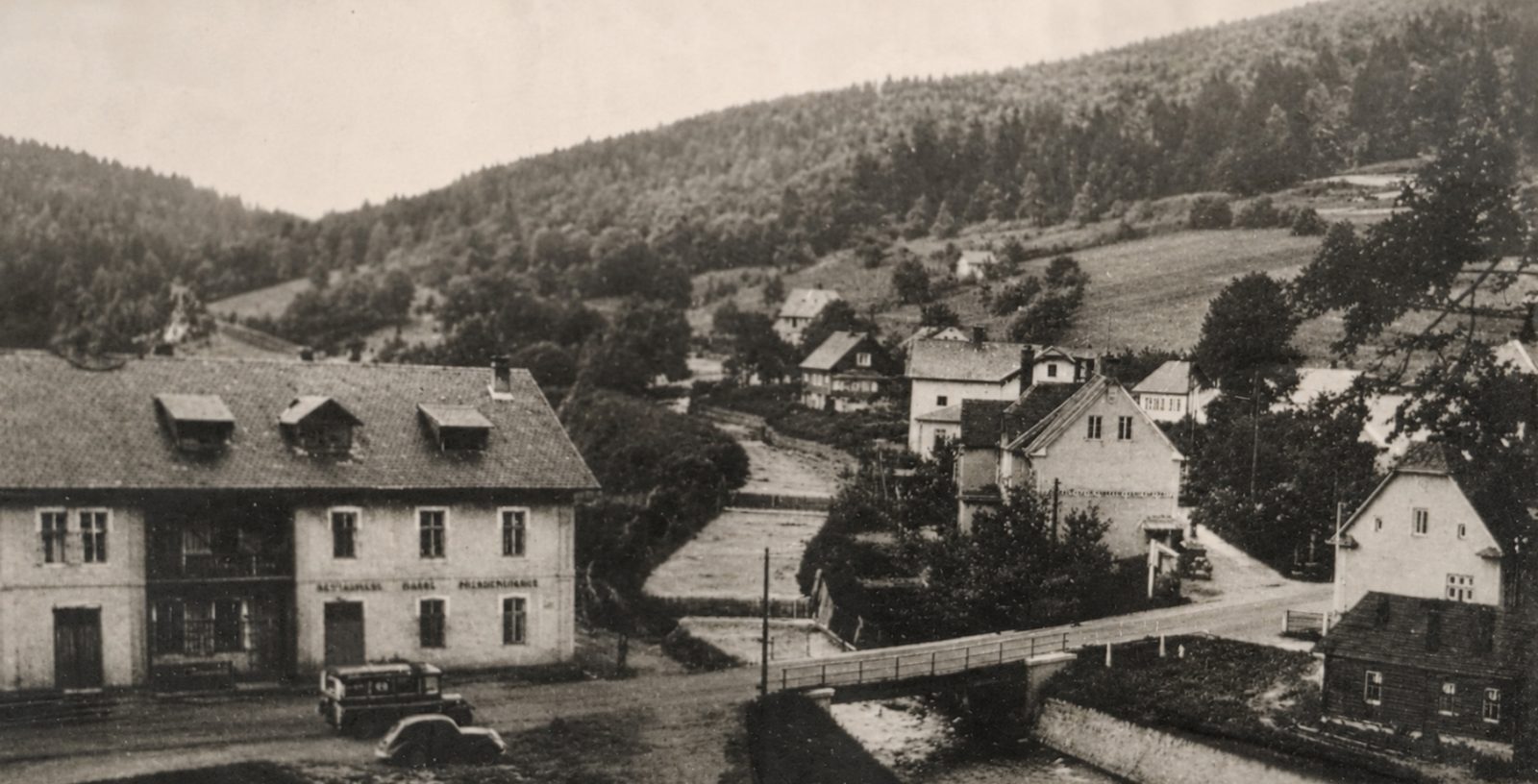 Dobový pohled na obec s původním domem u řeky